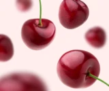 Photograph of cherries floating around in front of a light pink background to highlight the cherry flavour of DulcoLax Liquid.