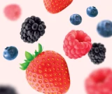 Photo d’une douzaine de petits fruits mélangés (fraises, bleuets, framboises et mûres) flottant sur un fond rose pâle pour mettre en valeur le goût délicieux et les arômes naturels des Soft Chews