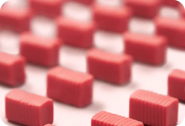 Rows of red, rectangular gums arranged on a surface.
