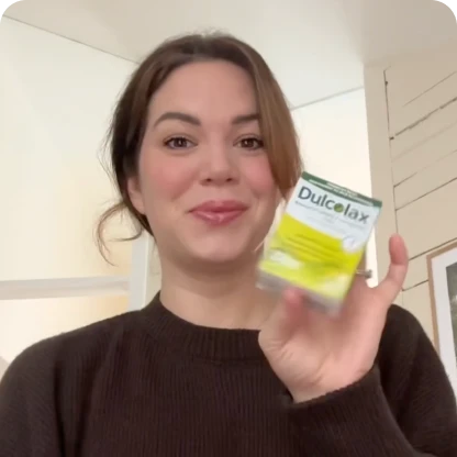 Person holding a Dulcolax product package, smiling.