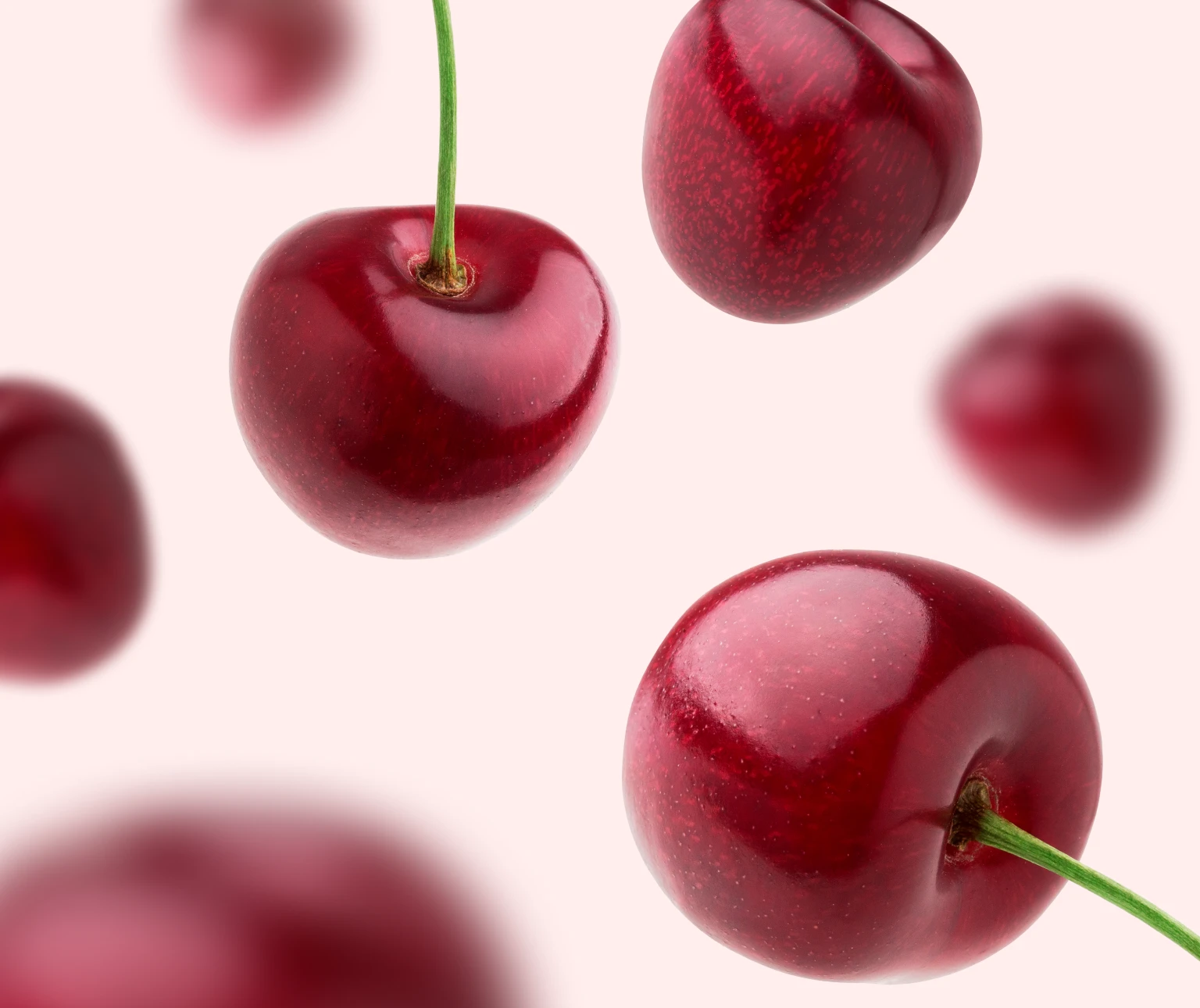 Photo d’une douzaine de cerises flottant sur un fond rose pâle pour mettre en valeur le goût de DulcoLax Liquide